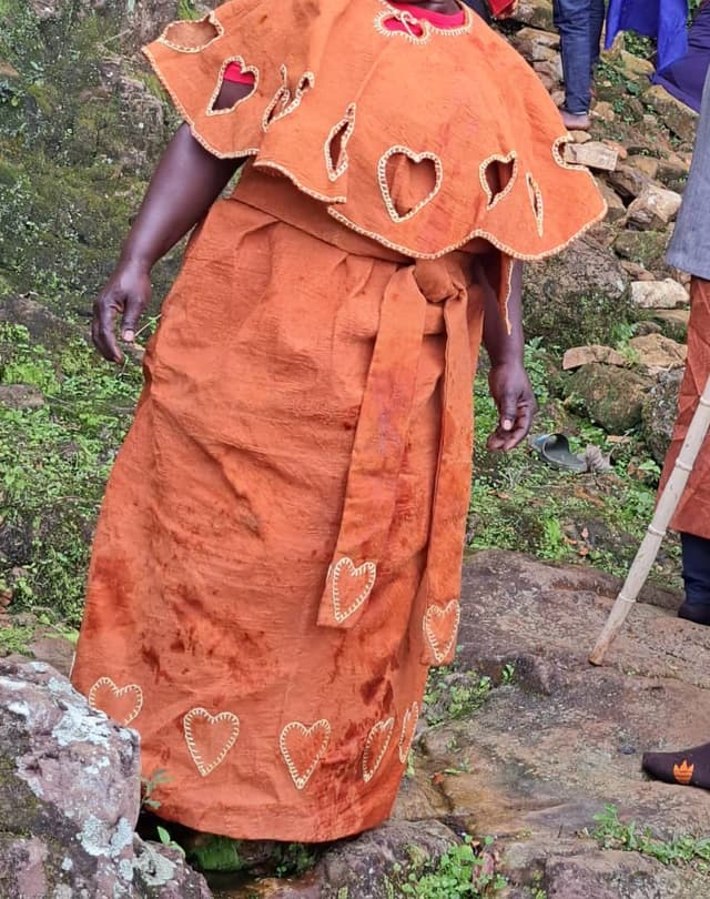 Bark cloth dress with decorative heart cutouts and cowrie trim