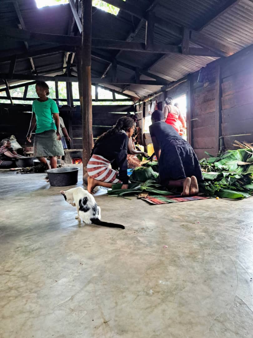Women preparing food on banana leaves in the cookhouse