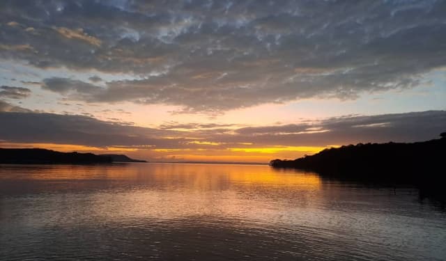Golden sunset reflecting on calm Lake Victoria water