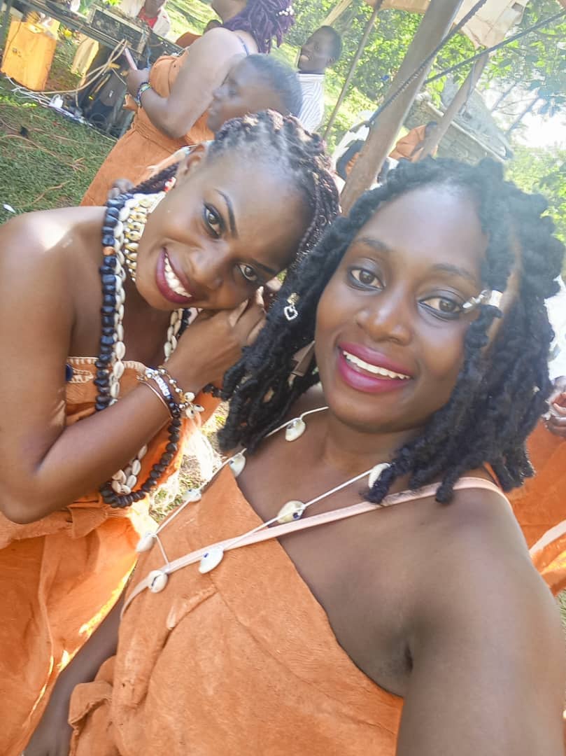 Two women wearing cowrie necklaces