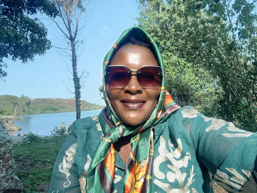 Queen Nalubaale with green scarf, lake behind