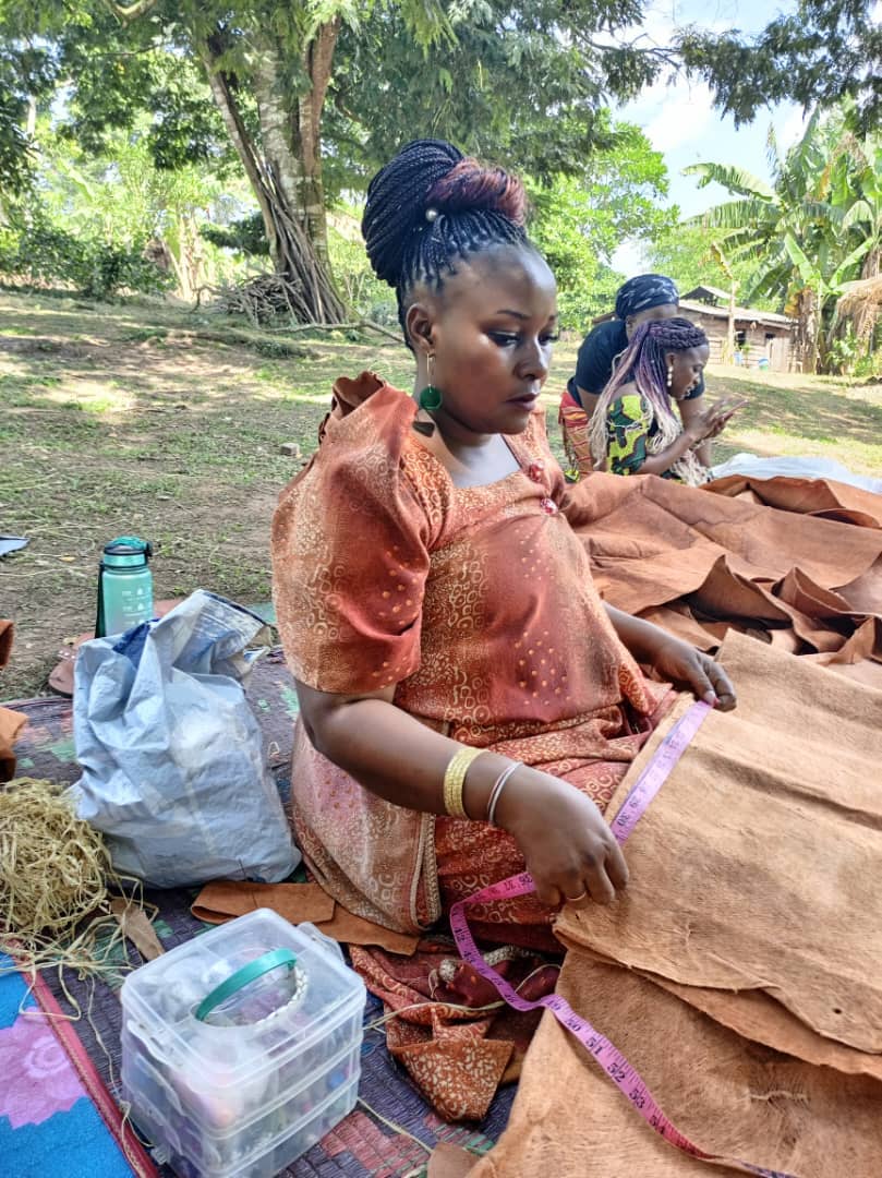 Mama Nalubaale measuring bark cloth with tape